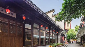 A traditional Chinese building with wooden doors, large windows, and red lanterns. - Hangzhou Utea Guesthouse (Hangzhou)