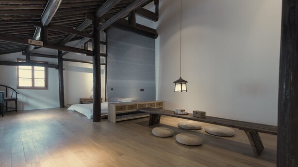 A room with a wooden floor, a bed with a white mattress, a bench, and a small table. - Hangzhou Utea Guesthouse (Hangzhou)