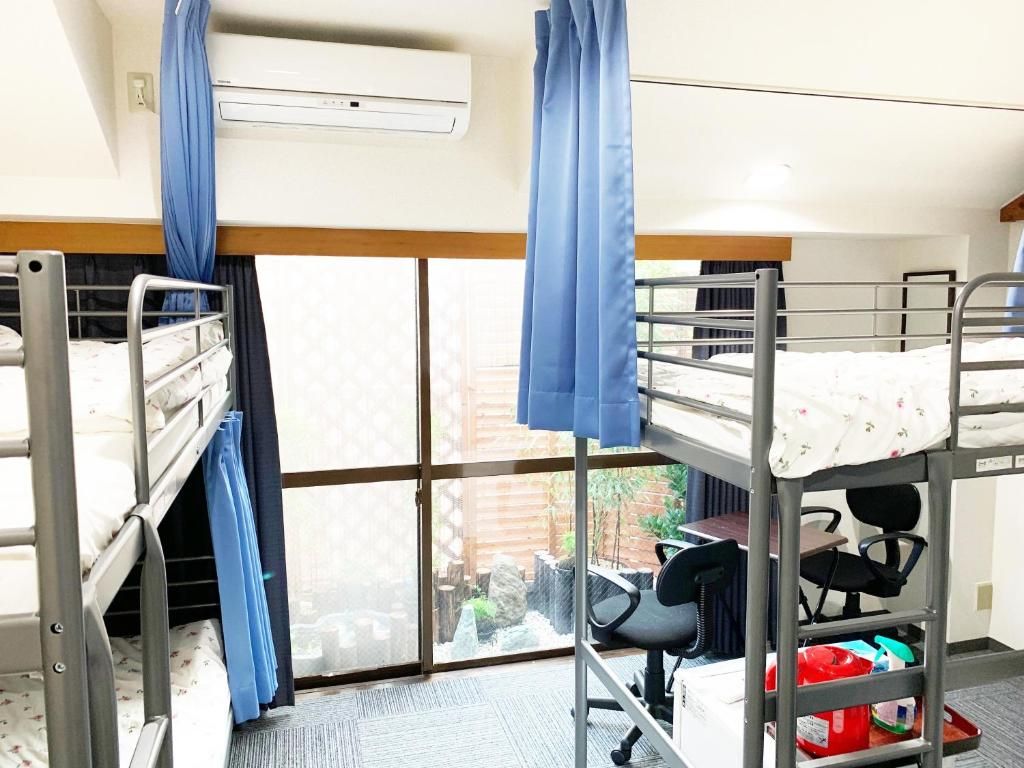 Une chambre avec des lits superposés, un bureau et une chaise.