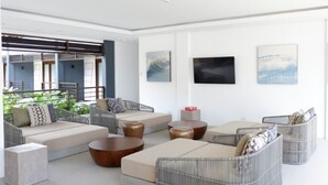 Una sala de estar moderna con un sofá, una mesa de centro y un televisor montado en la pared.