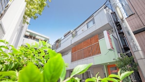 A multi-story building with a green facade and a wooden panel on the ground floor. - Akasaka-no Sato - Caters to Women - Hostel (Tokyo)