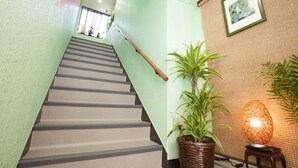 A staircase with a handrail, a potted plant, and a wall-mounted lamp. - Akasaka-no Sato - Caters to Women - Hostel (Tokyo)