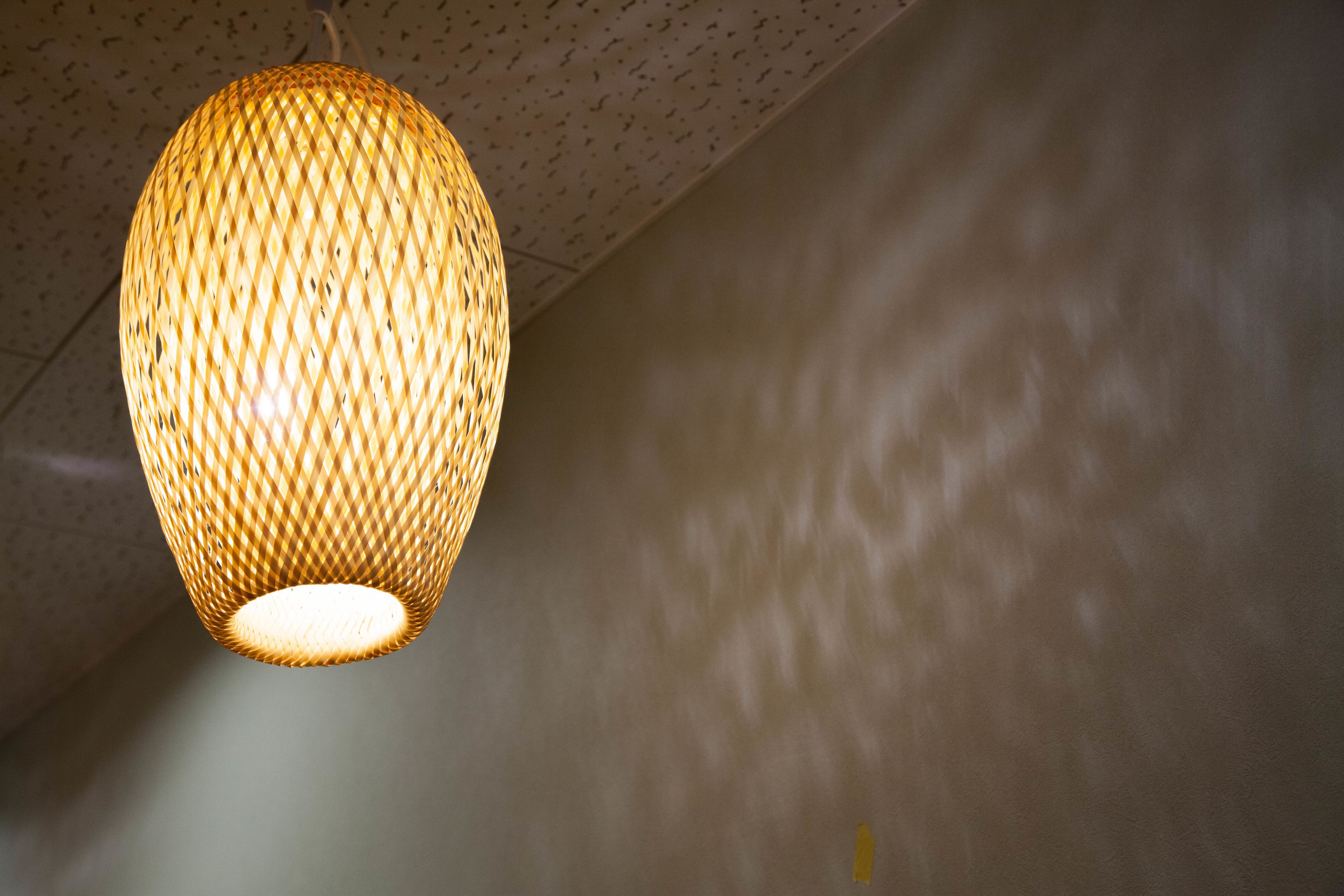 A woven light fixture hanging from a ceiling.