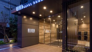 A hotel entrance with glass doors, a modern facade, and illuminated signage. - Belken Hotel Kanda (Tokyo)