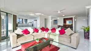 Ein modernes Wohnzimmer mit zwei Sofas, einem Couchtisch und einem Essbereich im Hintergrund.