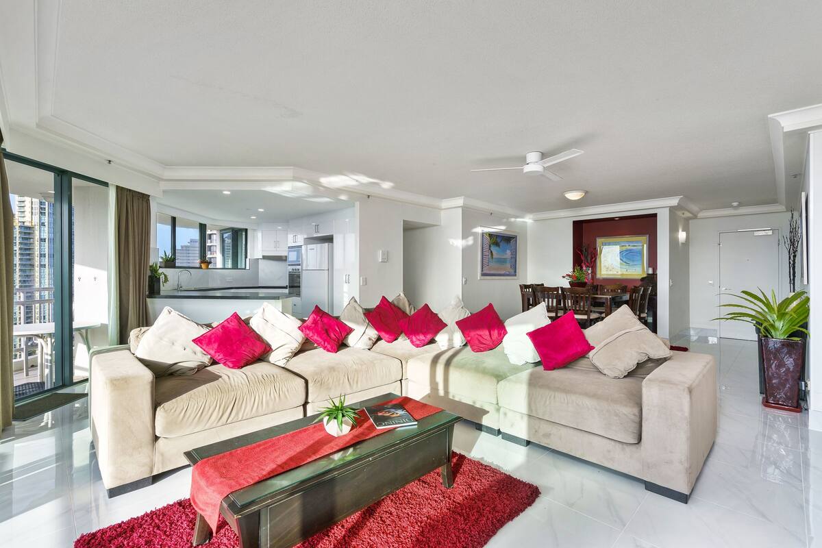 Ein modernes Wohnzimmer mit zwei Sofas, einem Couchtisch und einem Essbereich im Hintergrund.