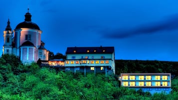 Vista frontal de la propiedad por la tarde o noche