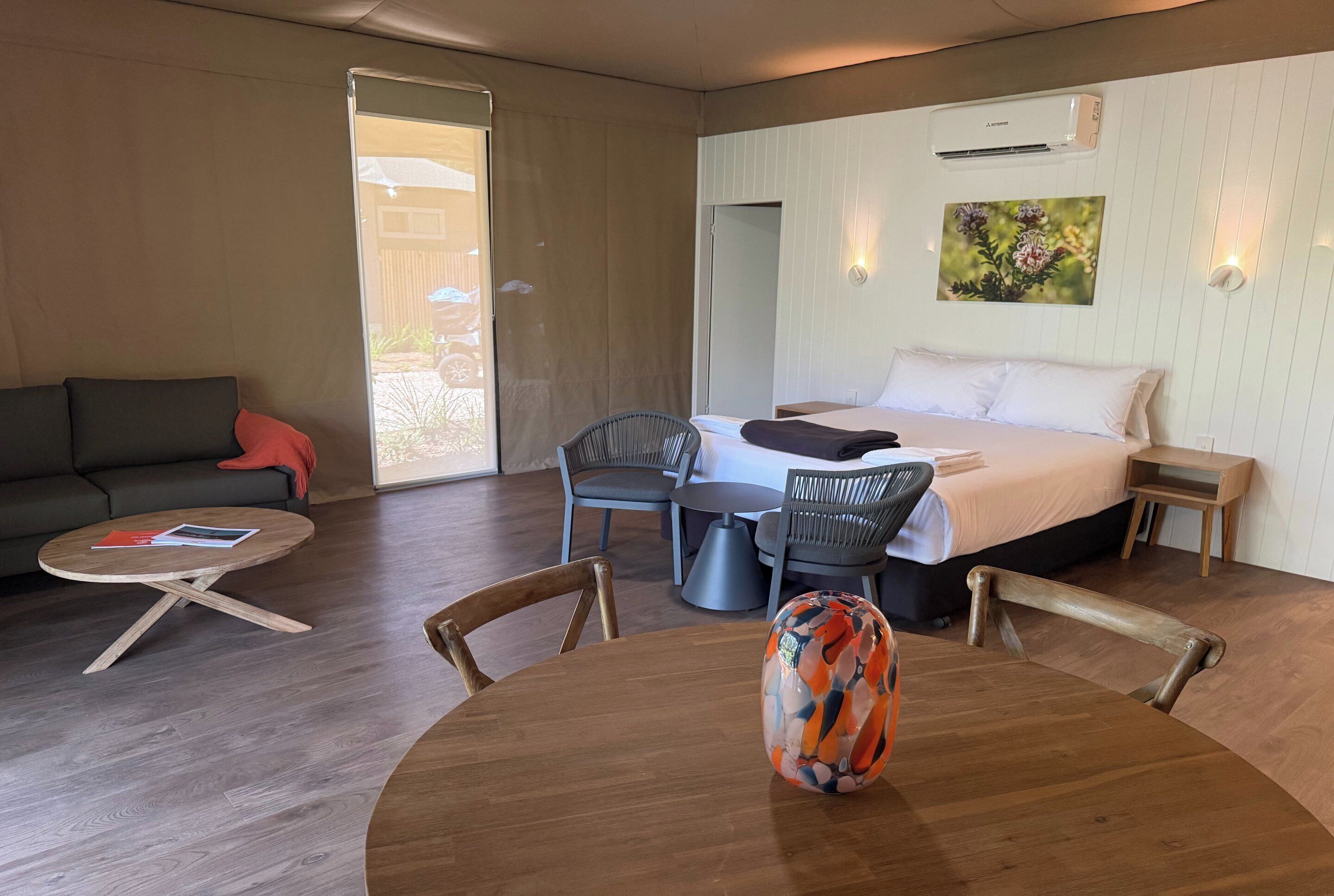 Habitació d'hotel amb llit, taula de menjador, sofà i cadira.