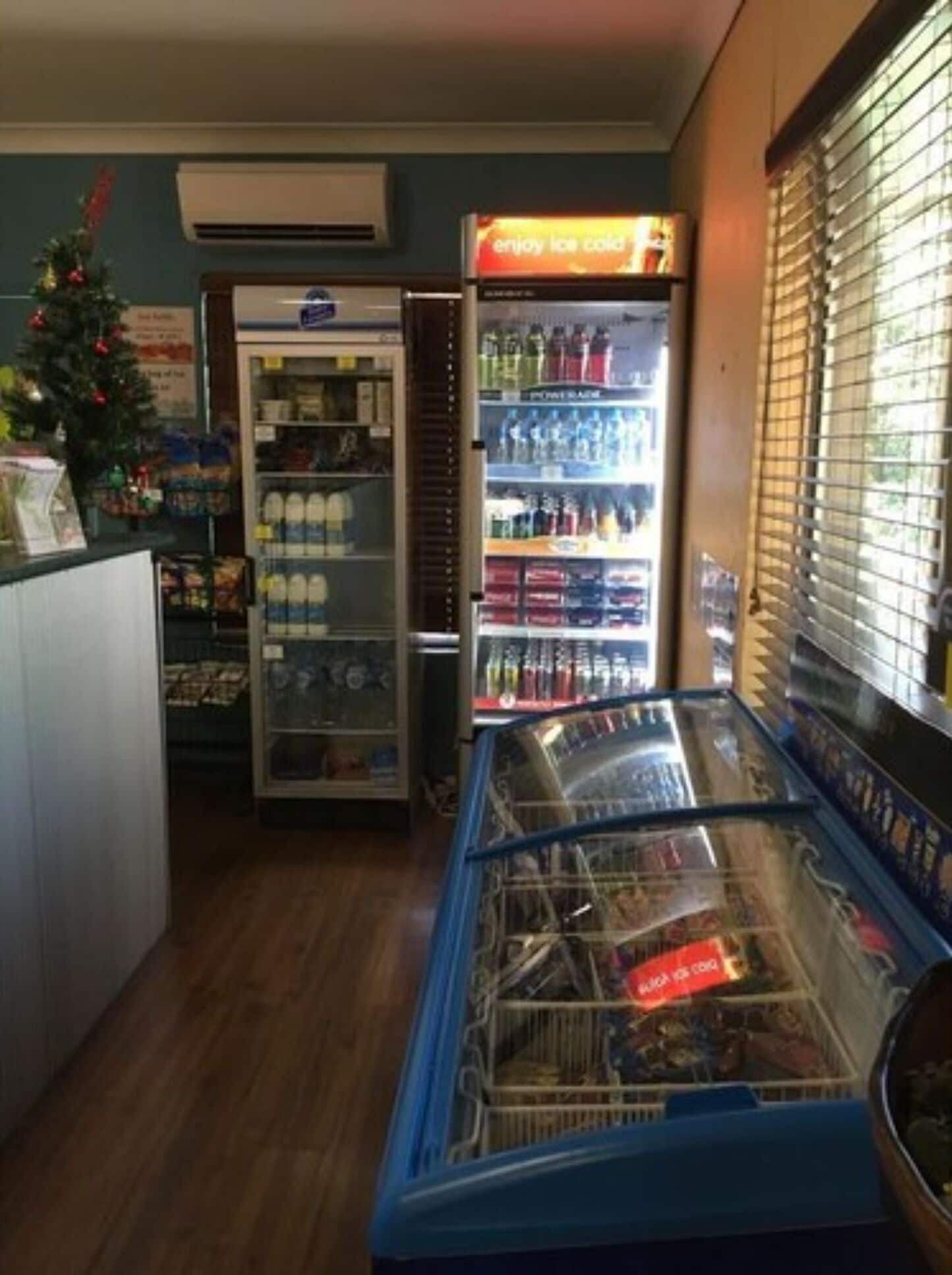 A small ice cream parlor with a freezer, a refrigerator, and a display case.