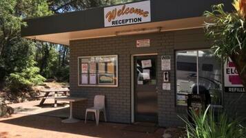 A reception area with a 'Welcome' sign, a picnic table, and a bench.