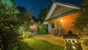 Een huis met een houten gevel, een veranda en een goed verlichte ingang.