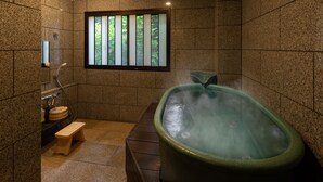 A spa room with a hot tub, a wooden bench, a window with vertical blinds, and a tiled wall.