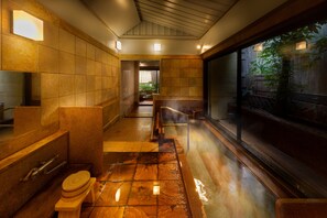 A modern bathroom with a wooden floor, a large mirror, and a bench. - Arima onsen Koki (Kobe)