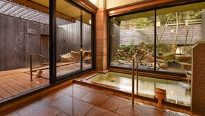 A traditional Japanese-style interior with tatami flooring, sliding doors, and a view of an outdoor rock garden.