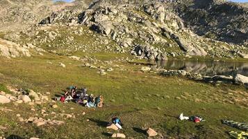 A group of people camping in a mountainous area with a lake.