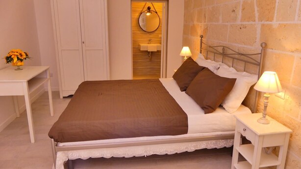 Ein Schlafzimmer mit einem Bett, Nachttischen, einem Schrank und einem Spiegel.
