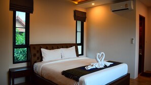 A neatly made bed with a white comforter and pillows, a brown headboard, and a window with a view of greenery. - Poonsiri Private Pool Villa Aonang (Krabi)