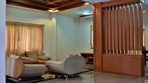 A modern living room with a sofa, a coffee table, and a wooden partition. - Poonsiri Private Pool Villa Aonang (Krabi)