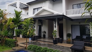 A two-story house with a covered porch, potted plants, and outdoor seating. - Krissna Villa Siem Reap (Siem Reap)