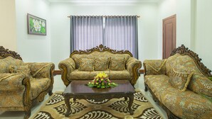 A room with two ornate sofas, a coffee table with a floral centerpiece, and a patterned rug. - Krissna Villa Siem Reap (Siem Reap)