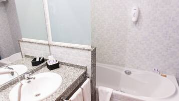 Une salle de bain avec deux lavabos, une baignoire et un miroir.