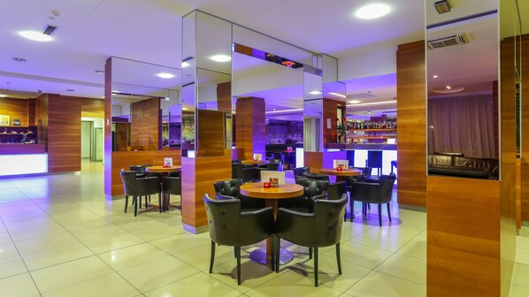 A modern hotel lobby with a bar area, multiple seating arrangements, and a reception desk. - Hotel Trakoscan (Bednja)