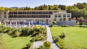 A hotel with a modern design, featuring a central courtyard with outdoor seating and a pathway leading to the entrance. - Hotel Trakoscan (Bednja)