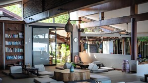 A modern lounge area with seating, a bookshelf, and a coffee station. - Samahita Retreat Koh Samui - SHA Plus (Koh Samui)