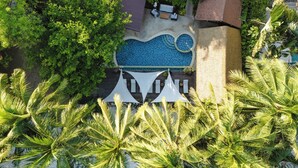 A rooftop pool with a blue mosaic design, surrounded by lush greenery and palm trees. - Samahita Retreat Koh Samui - SHA Plus (Koh Samui)