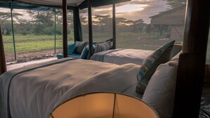 Een slaapkamer met twee bedden, uitzicht op het landschap en een raam met gordijnen.