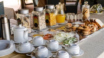 A breakfast buffet with various food items, condiments, and tea sets.
