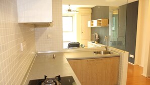 Una cocina compacta con estufa a gas, pileta y armarios de madera.