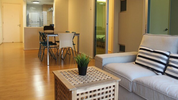 Una sala moderna con un sofá, una mesa de centro y un comedor con sillas y una mesa.
