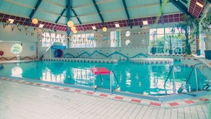 An indoor swimming pool with clear water, tiled walls, and a high ceiling with visible beams. - Europarcs IJsselmeer (Medemblik)