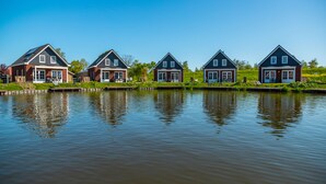 A row of five houses by a calm body of water. - Europarcs IJsselmeer (Medemblik)