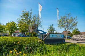 A sign for EuroParcs with a clear sky and greenery in the background. - Europarcs IJsselmeer (Medemblik)