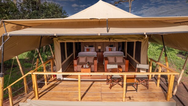 A tented accommodation with two bedrooms, a wooden deck, and a view of the surrounding greenery. - Angata Ngorongoro (Ngorongoro)