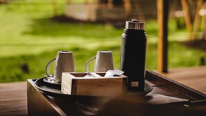 A tray with a thermos, two mugs, and a box of tissues on a wooden table. - Angata Ngorongoro (Ngorongoro)