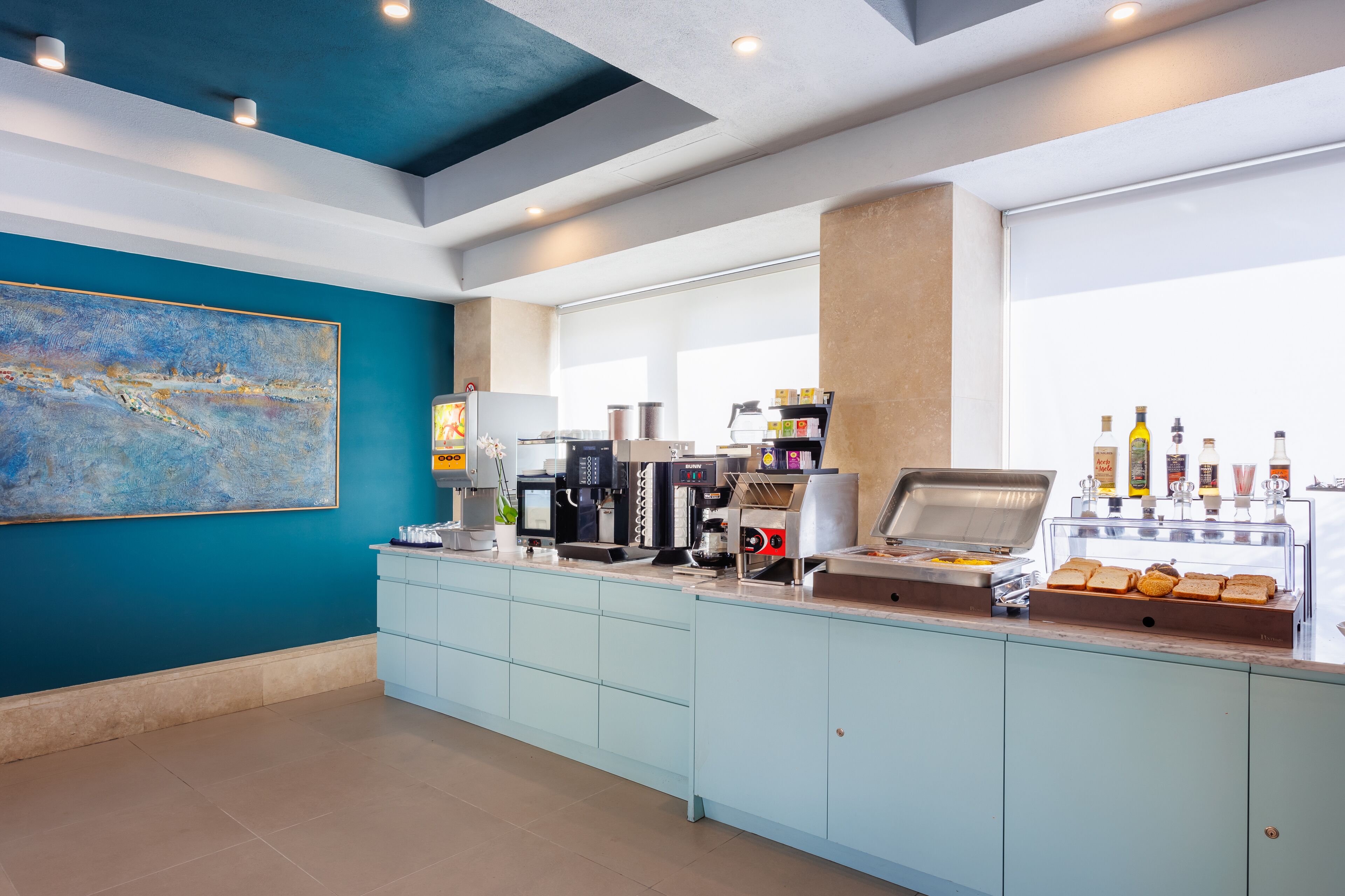 Een moderne ontbijtbar met een koffieapparaat, broodrooster en drankdispensers.