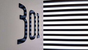 A wall with the number '301' and a window with horizontal blinds.