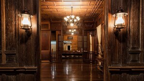 A wooden hallway with two wall-mounted lanterns, a chandelier, and a traditional interior design. - Casa Simeon (Bacacay)