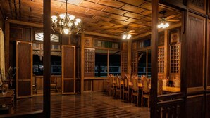 A traditional wooden room with a high ceiling, ornate wooden doors, and a chandelier. - Casa Simeon (Bacacay)
