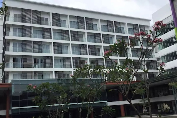 A multi-story building with a grid of windows and balconies.