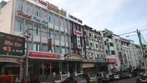 Un edificio de hotel de varios pisos con diversa señalización, incluyendo 'Hotel Pop Ash' y 'Hotel YTS'.