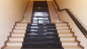 Una escalera con escalones de color negro y beige, que ascienden.