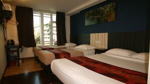 Habitación de hotel con dos camas, un ventanal grande, un cuadro en la pared y un escritorio con cafetera.