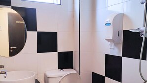 Un baño con inodoro, lavabo y ducha.