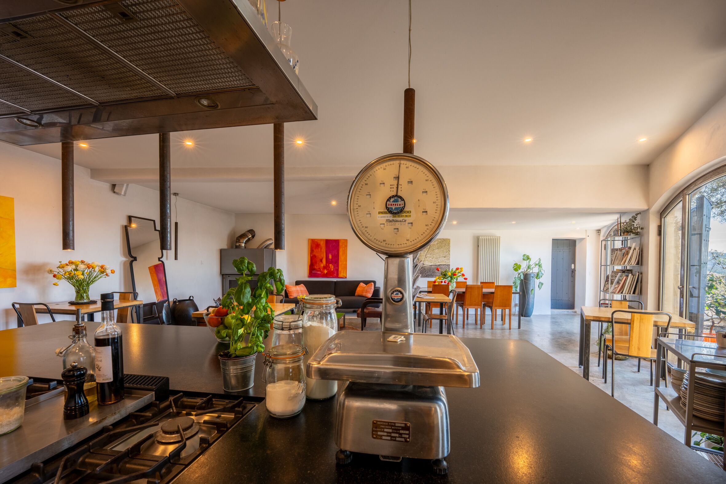 A modern kitchen with a central island, a gas stove, and various kitchen utensils.