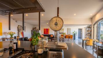 A modern kitchen with a central island, a gas stove, and various kitchen utensils.