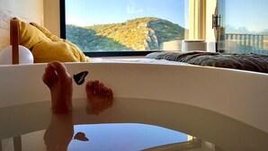 A room with a large window, a bed, and a bathtub. - Metafort (Méthamis)